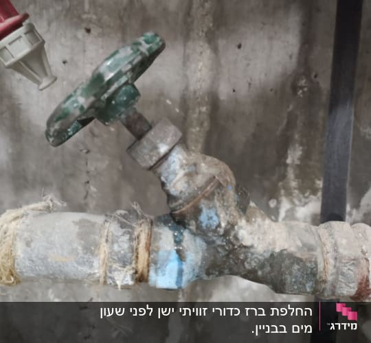 ברז מתכת ישן עם ידית ירוקה וחיבורים חלודים